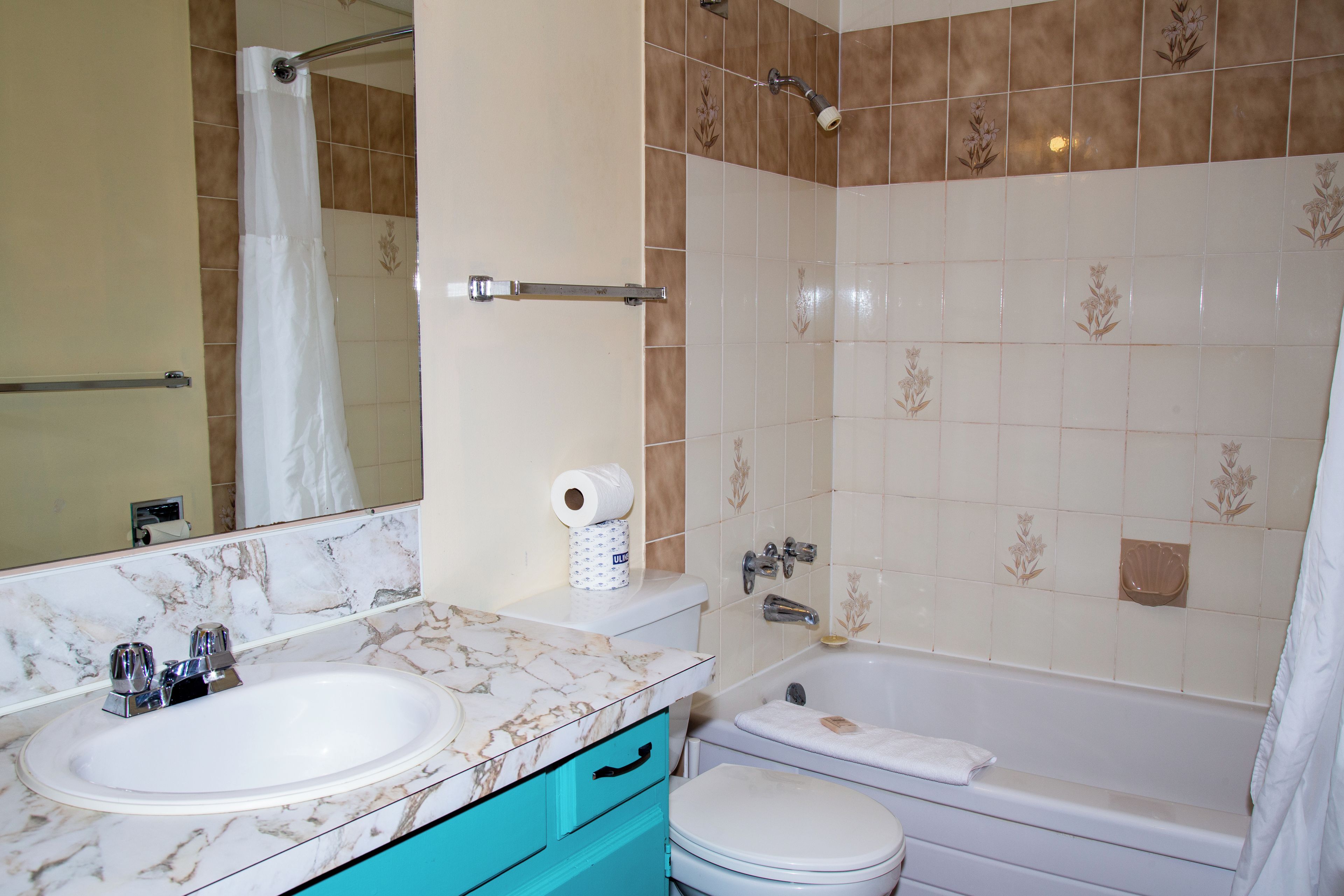 A bathroom with a marble sink, a toilet, and a bathtub.
