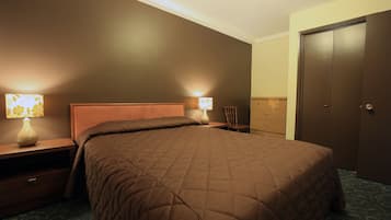 Ein Schlafzimmer mit einem großen Bett, zwei Nachttischen mit Lampen, einem Schminktisch und einem Kleiderschrank.