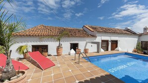 A pool area with a tiled deck, a red slide, and potted plants. - Holidays Tenerife breakfast inclusive wifi pool fr (La Laguna)