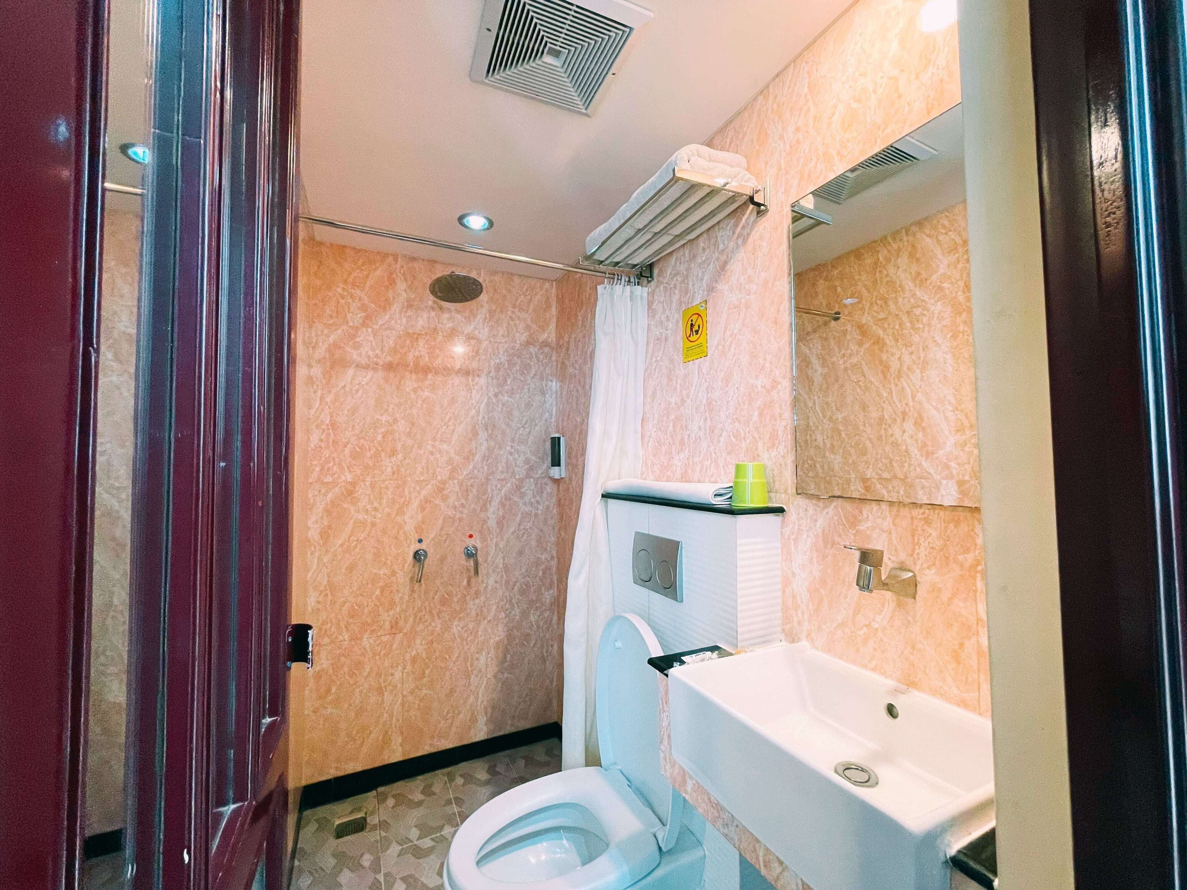 Ein Badezimmer mit Toilette, Waschbecken und Duschbereich.