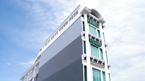Un edificio de hotel alto de estilo arquitectónico clásico, con un cartel grande que dice “Hotel” en la parte superior y un cartel que dice “Panorama” en el lateral.