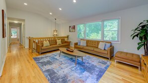 A spacious living room with two sofas, a coffee table, and a large window with blinds. - Large 5BR House w/ Backyard, Deck, and Patio (Princeton)