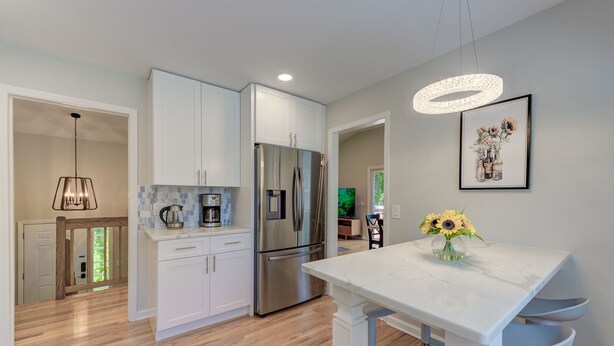 A modern kitchen with white cabinets, stainless steel appliances, and a marble countertop. - Large 5BR House w/ Backyard, Deck, and Patio (Princeton)