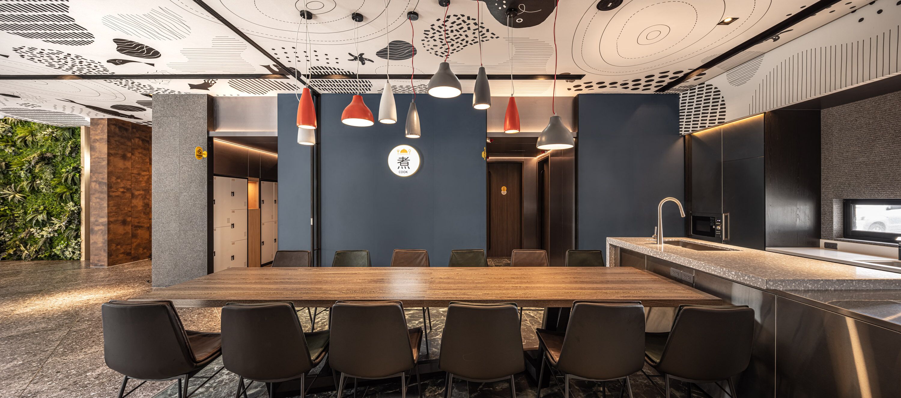 A modern conference room with a long wooden table, six chairs, and pendant lighting.