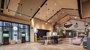 A spacious lobby with a high ceiling, modern lighting fixtures, and a reception area with self-service machines. - The Moment Hotel Hualien by Lakeshore (Xincheng)