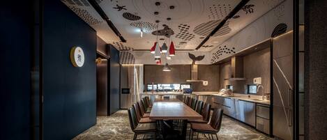 Una cocina moderna con una isla central, electrodomésticos de acero inoxidable y una pared de acento azul oscuro.