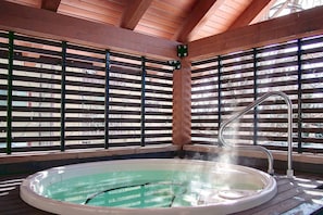 A hot tub with a wooden deck and metal railings, surrounded by a wooden ceiling structure. - August Monthly Rates! Summer Pool + Hot Tub-Grill-W/D in Unit-Walk to Mtn/Steps to Free Town Bus (Steamboat Springs)