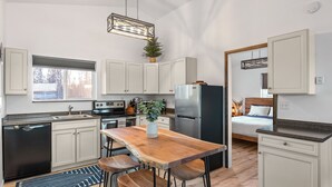 A modern kitchen with a wooden island, white cabinets, and stainless steel appliances. - DENALI PENTHOUSE, lakefront near Talkeetna and Denali State Park  (Trapper Creek)
