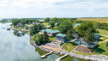 Une propriété au bord du lac comprenant plusieurs maisons, des quais et un bateau amarré.
