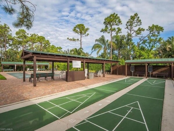 A shuffleboard court with a covered seating area and a pavilion.