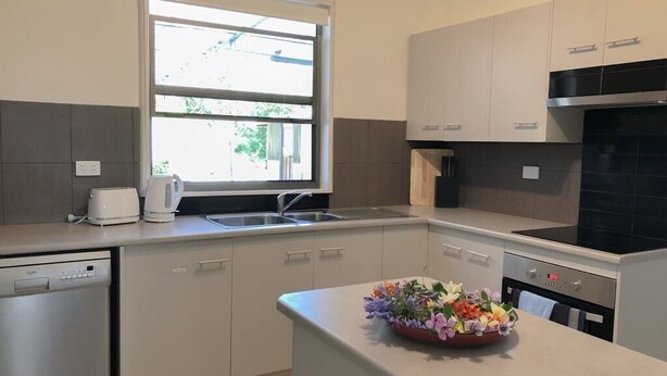 A modern kitchen with a dishwasher, a built-in oven, and a window providing natural light. - Charlestown Central 5 Bedrooms Front House (Charlestown)