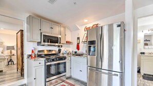A modern kitchen with stainless steel appliances, white cabinetry, and a red and white patterned rug. - 'Hilltop Hideaway' Branson Home w/ Trampoline! (Branson)
