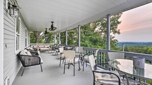 A covered porch with outdoor furniture, a table, and a view of the landscape. - 'Hilltop Hideaway' Branson Home w/ Trampoline! (Branson)