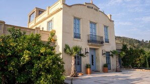 A two-story building with a balcony and a sign that reads 'Villa Luz'.