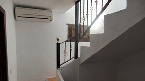 A staircase with a black railing and a white wall.