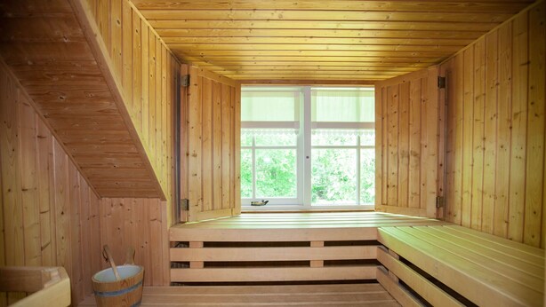 Una sauna con bancos de madera y un ventanal grande.