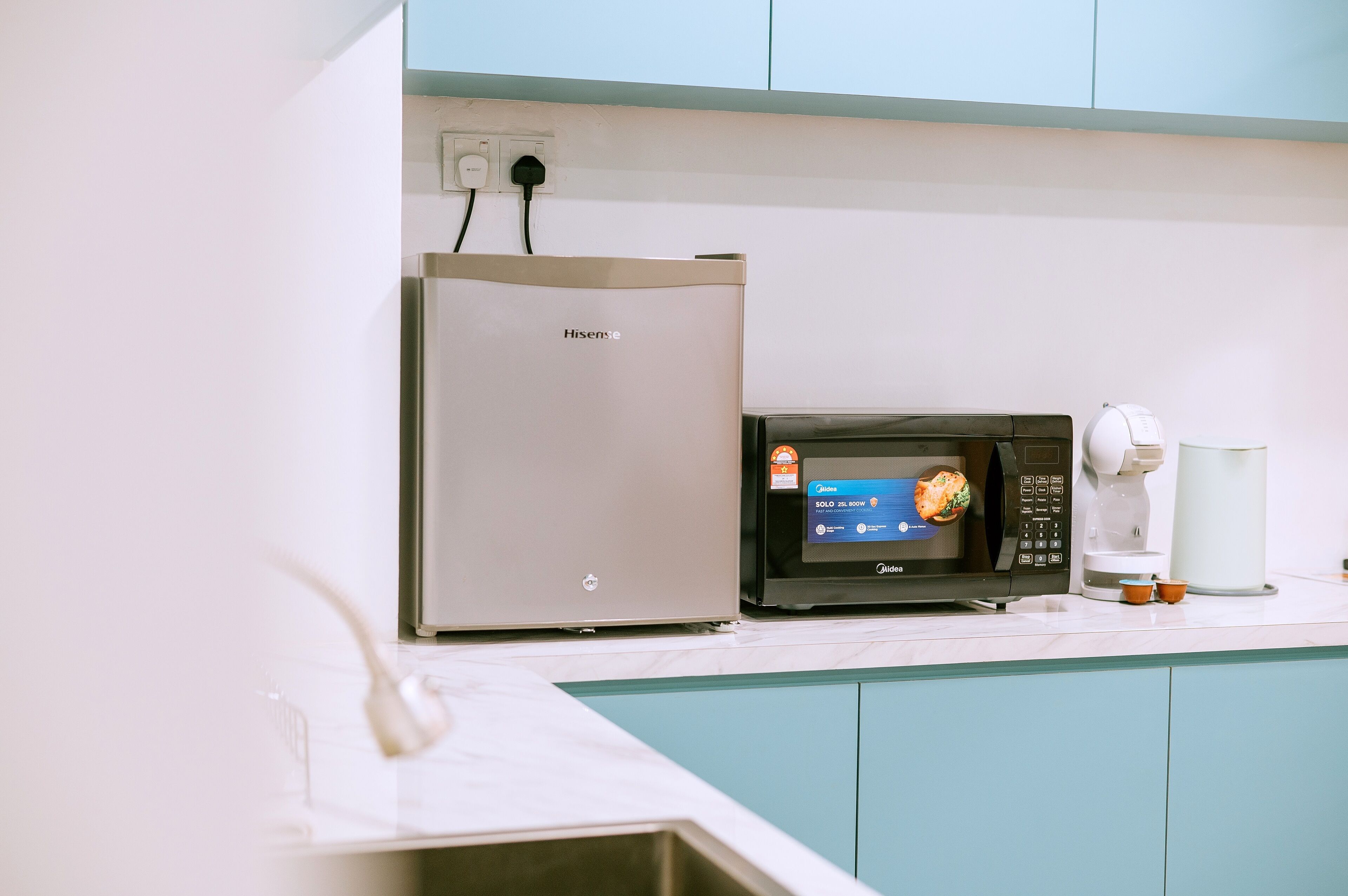 A kitchen with a Hisense refrigerator, a microwave, and a coffee maker on the counter.