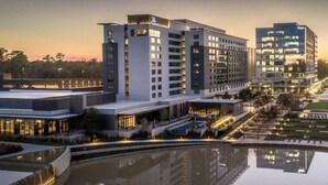 A modern hotel complex with multiple high-rise buildings, a reflective water feature, and well-lit pathways. - Resort Style 2 bed/2bath Apartment in Spring, Tx (Spring)