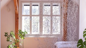 A room with a bed, a window, and a plant. - Apartment in the heart of Bled with views (Bled)