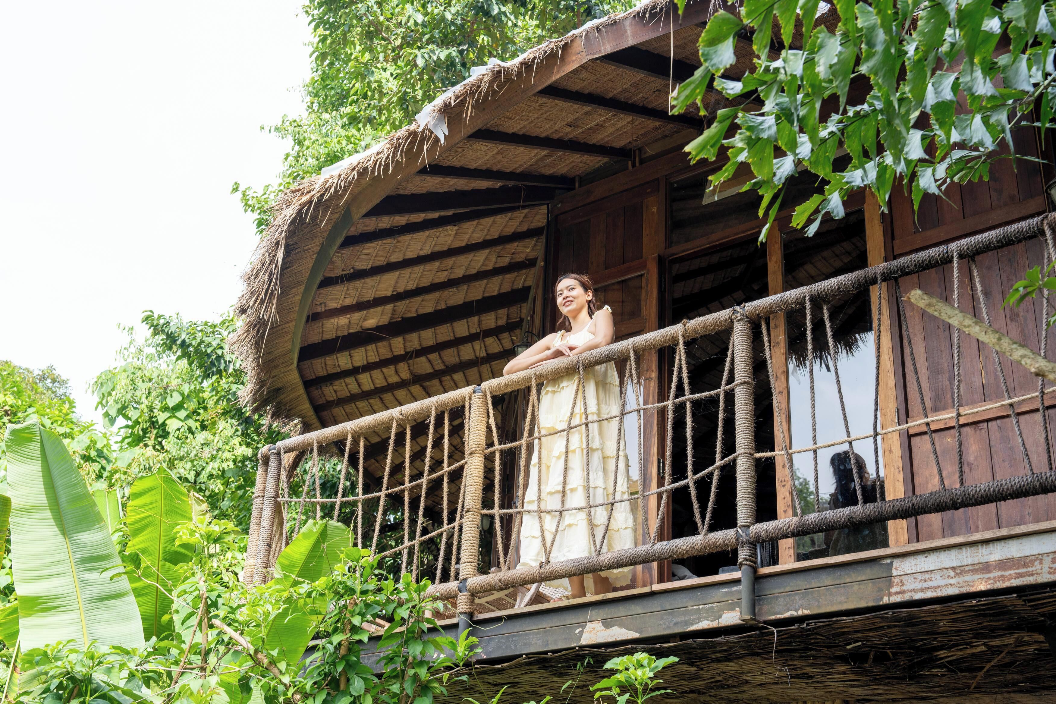 A rustic wooden structure with a thatched roof and a rope railing.