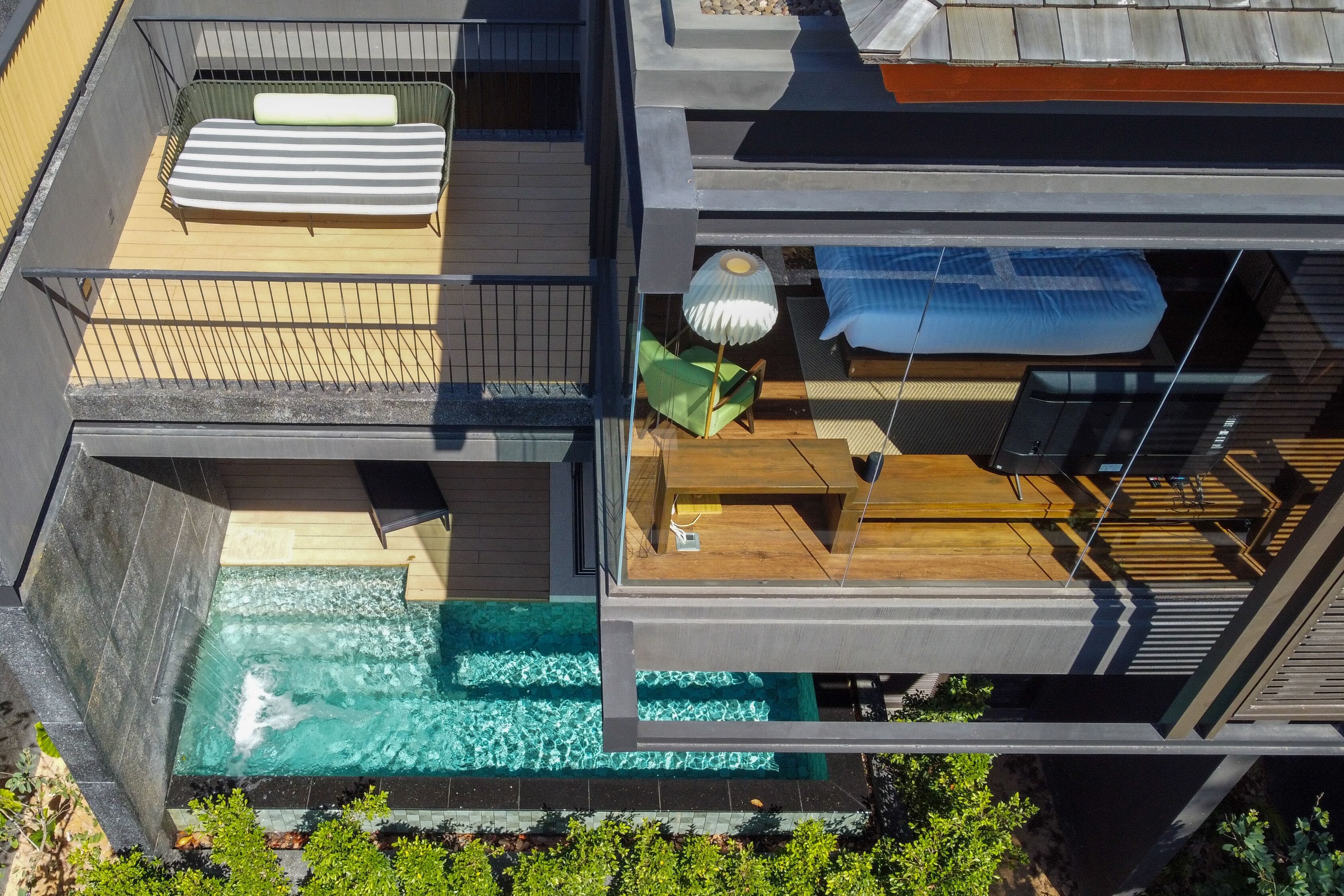 A modern house with a rooftop pool, a balcony with a sofa, and a dining area.