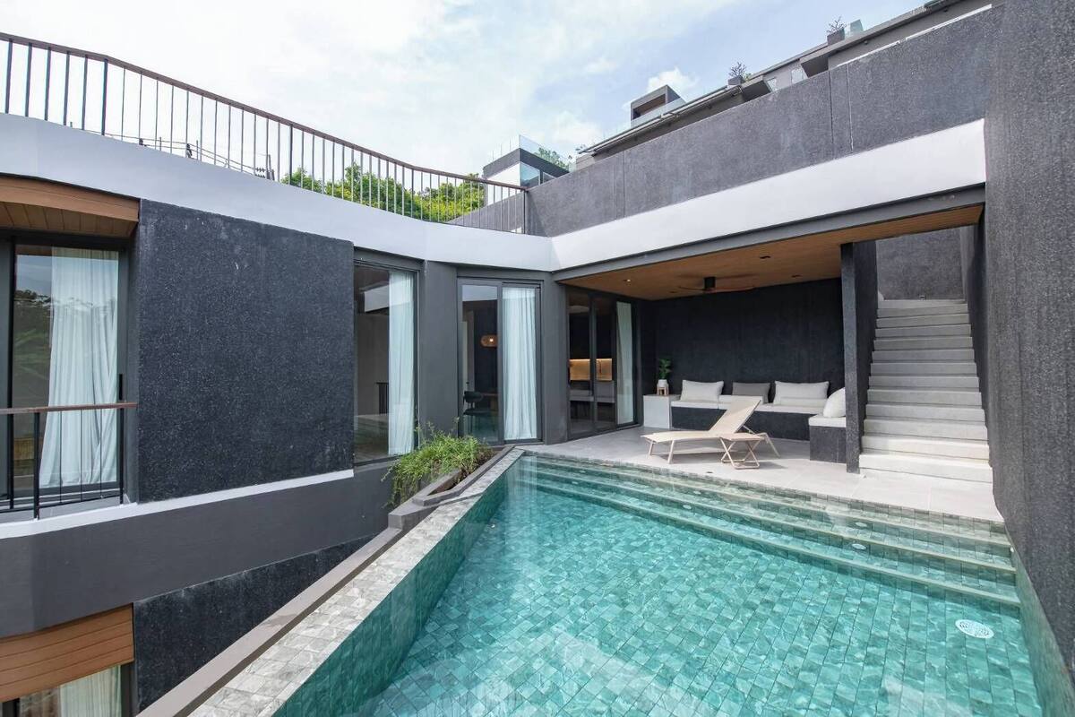 A modern house with a swimming pool, a staircase, and a balcony.