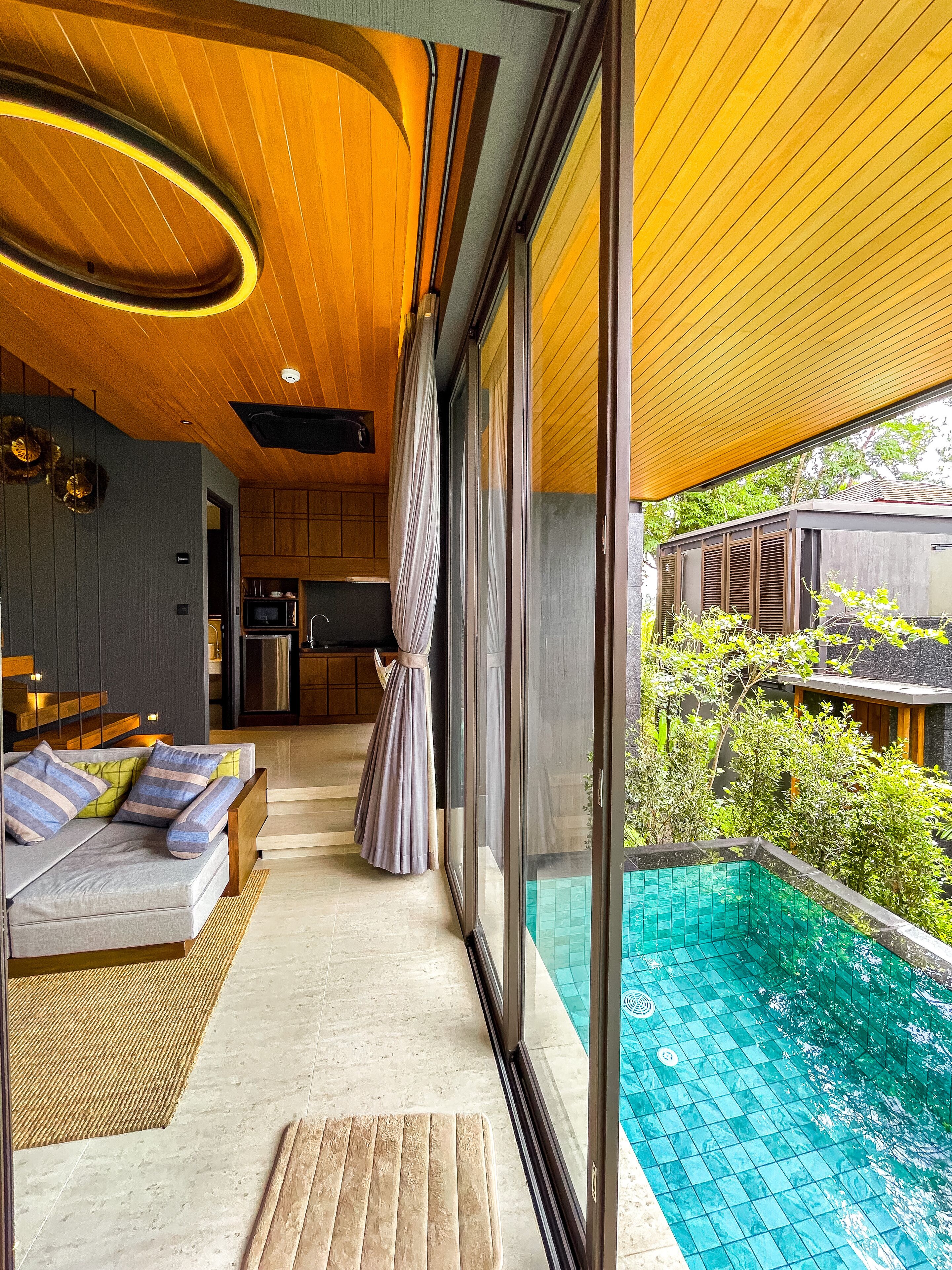 A modern interior with a pool area, wooden ceiling, and a view of the outdoors.