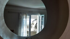 A circular window with a view of a balcony, a door, and a curtain. - Panoramic view Quiet private pool (Rasteau)