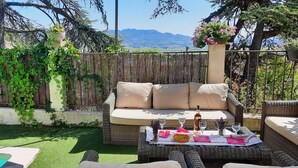 A patio with wicker furniture, a pool, and a view of mountains. - Panoramic view Quiet private pool (Rasteau)