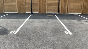 A parking area with four wooden doors, each marked with a number. - Cozy 1BR Apartment in Central Fort-Mahon-Plage with Private Parking (Fort-Mahon-Plage)