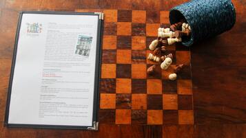 A wooden table with a chessboard and a document titled "The Bank" on it.