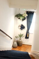 Una escalera con barandilla, una planta en maceta y jarrones decorativos.
