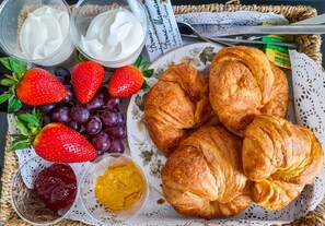 A plate with croissants, strawberries, grapes, and two types of spreads. - The Bank Hotel & Bistro (St Leonards-On-Sea)