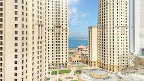 Un ensemble immobilier composé d’immeubles de grande hauteur, doté de plusieurs étages, d’une cour intérieure et offrant une vue sur la mer.