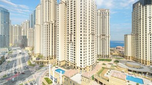 A high-rise residential building with multiple floors, a swimming pool, and a landscaped area.
