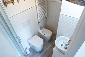 Ein kleines Badezimmer mit Toilette, Bidet und Waschbecken.