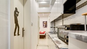Una cocina moderna con encimera de mármol, horno empotrado y microondas.