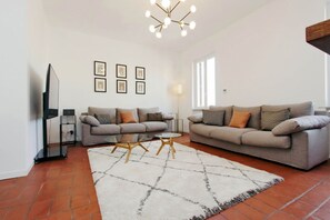 A living room with two sofas, a coffee table, a TV, and framed pictures on the wall.