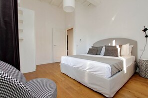 Ein Schlafzimmer mit einem Bett, einem Sessel und einer Tür.
