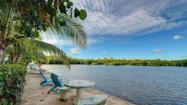 Une terrasse au bord du lac, avec des sièges extérieurs et une vue sur l’eau.