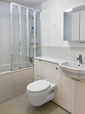 A modern bathroom with a glass-enclosed shower, a white sink, and a toilet. - Rare 1-bed Church Converted Apartment in London (London)