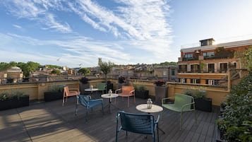 A rooftop terrace with outdoor seating and a view of the cityscape.
