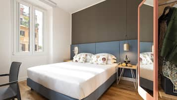 A modern bedroom with a large bed, bedside tables, a mirror, and a window with a view of buildings.