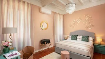 A bedroom with a bed, a desk, a chair, a small table, and a decorative wall piece.