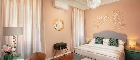 Un dormitorio con cama, escritorio, silla, mesita y un adorno en la pared.