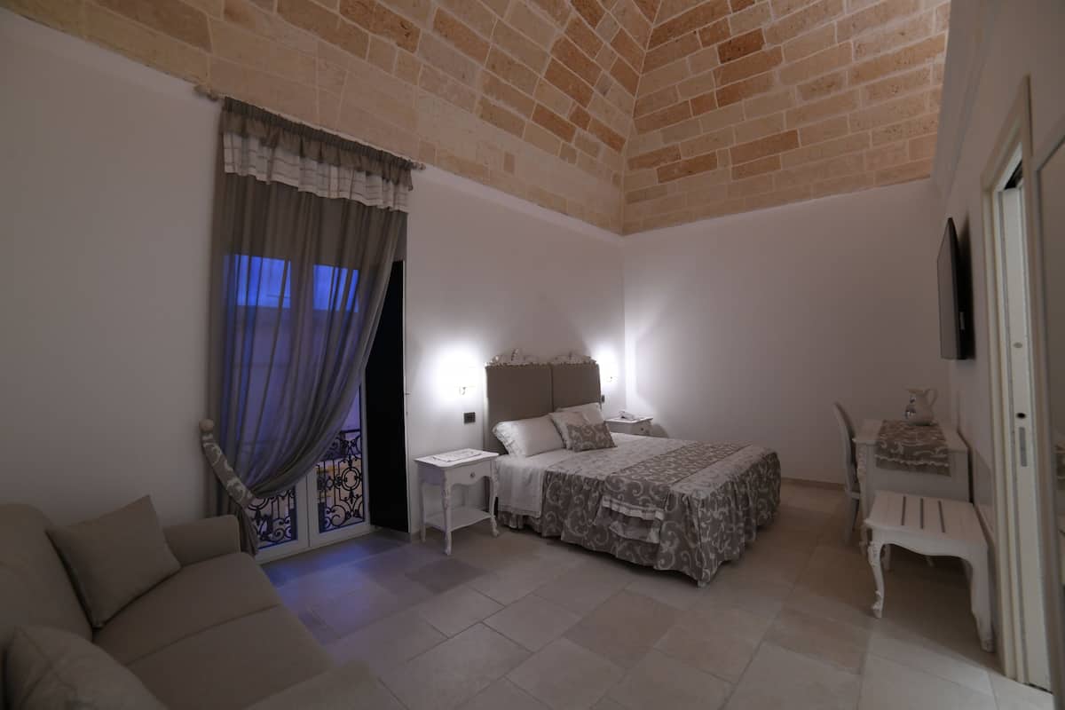 A bedroom with a bed, nightstand, and a chair.