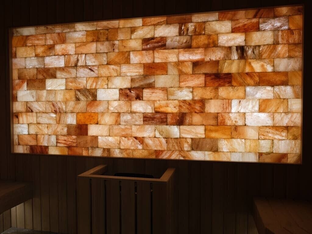 A wall with a mosaic of rectangular stone tiles in various shades of brown and beige.