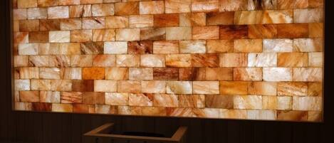 Pared con un mosaico de baldosas de piedra rectangulares en varios tonos de marrón y beige.