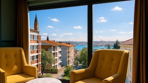 A room with two yellow armchairs and a small marble table, large windows with a city view. - Fragments Hotel (Istanbul)