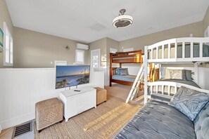 Cozy bedroom with a bunk bed, TV, and comfortable sofa.